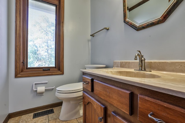 bathroom with tile patterned flooring, vanity, and toilet