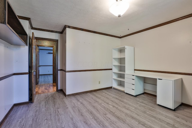 interior space with a textured ceiling, light hardwood / wood-style floors, and crown molding