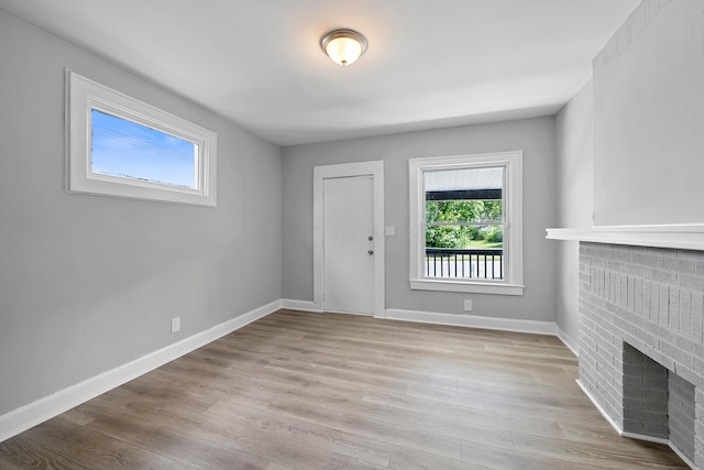 interior space featuring light hardwood / wood-style flooring and a brick fireplace