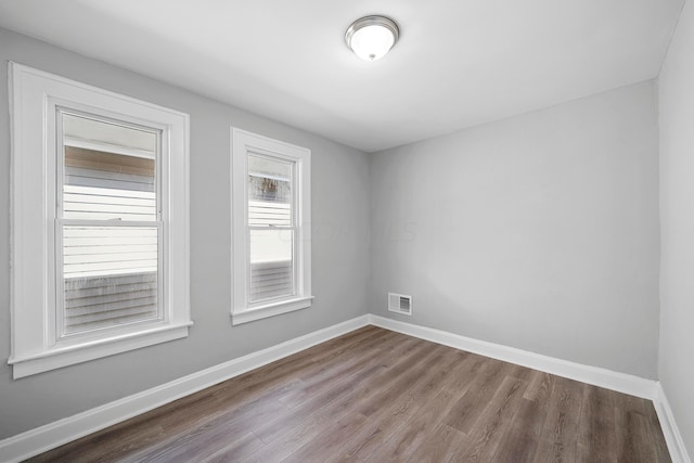 unfurnished room with hardwood / wood-style flooring