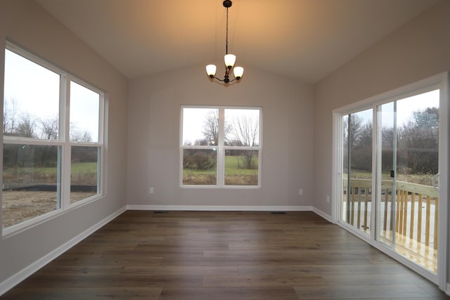 unfurnished dining area featuring lofted ceiling, a notable chandelier, and dark hardwood / wood-style floors