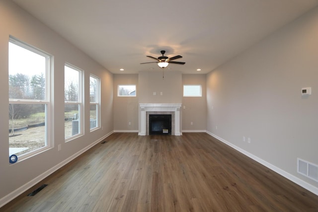 unfurnished living room featuring ceiling fan, hardwood / wood-style floors, and a tile fireplace