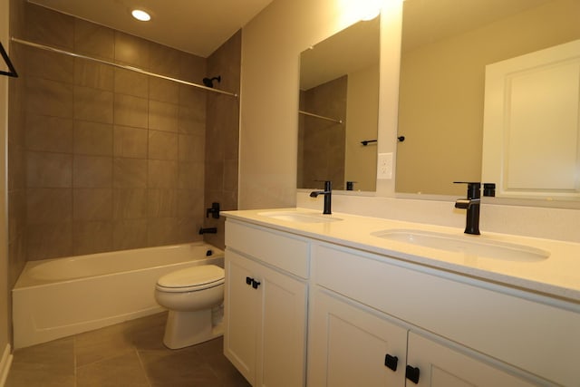 full bathroom with toilet, tile patterned flooring, tiled shower / bath, and vanity