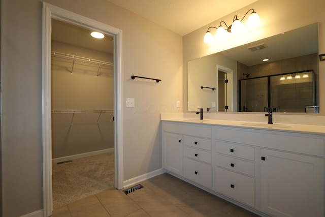 bathroom featuring an enclosed shower, vanity, and tile patterned flooring