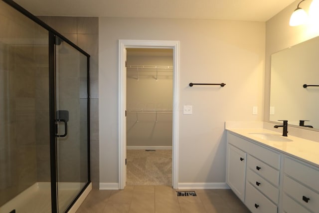 bathroom featuring vanity, tile patterned flooring, and a shower with shower door