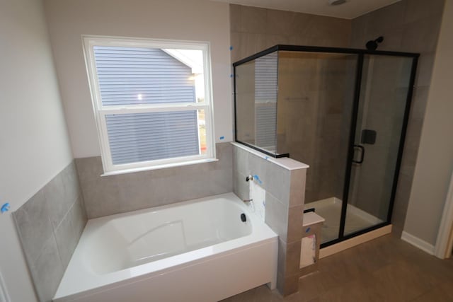 full bathroom with a stall shower and a garden tub