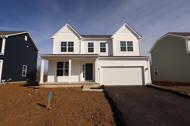 view of front of house featuring covered porch, aphalt driveway, board and batten siding, and a garage