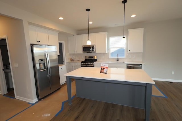 kitchen with appliances with stainless steel finishes, a sink, white cabinets, and decorative backsplash