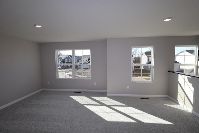 spare room featuring carpet floors, visible vents, baseboards, and recessed lighting