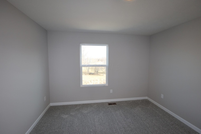 empty room featuring carpet floors, baseboards, and visible vents