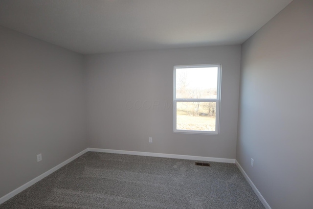 carpeted empty room with visible vents and baseboards