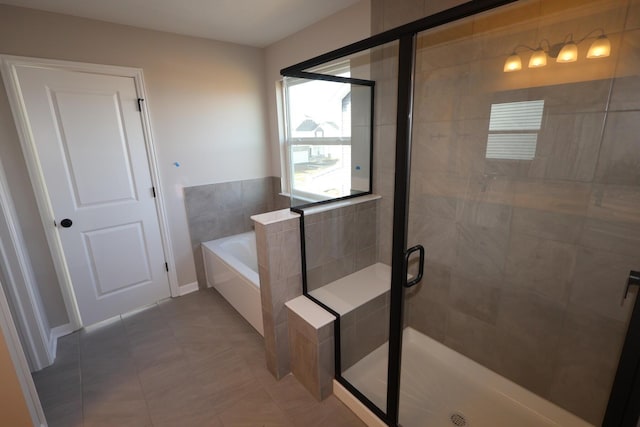 bathroom featuring tile patterned floors, a garden tub, and a shower stall