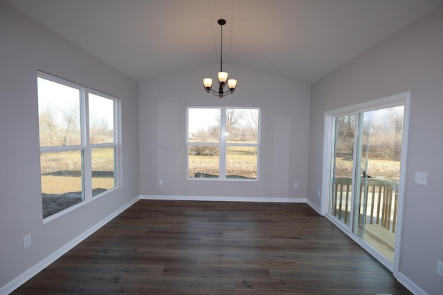 unfurnished dining area featuring lofted ceiling, a healthy amount of sunlight, dark wood-style flooring, and an inviting chandelier