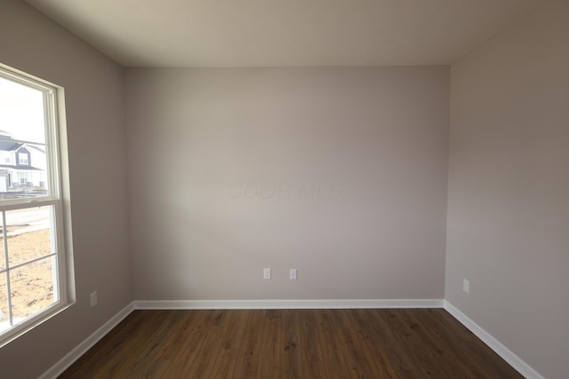 unfurnished room with dark wood-style floors and baseboards