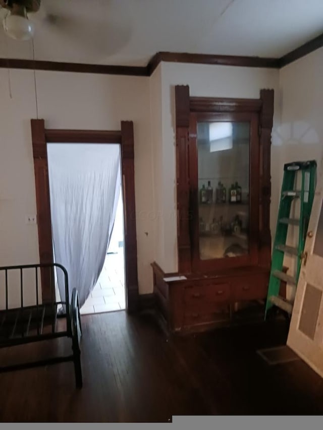 bedroom with dark hardwood / wood-style flooring and ornamental molding