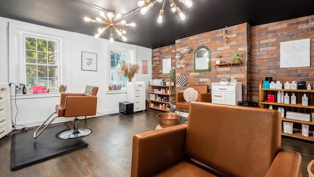 sitting room with dark hardwood / wood-style flooring, a chandelier, and brick wall