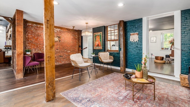 sitting room featuring hardwood / wood-style floors and brick wall