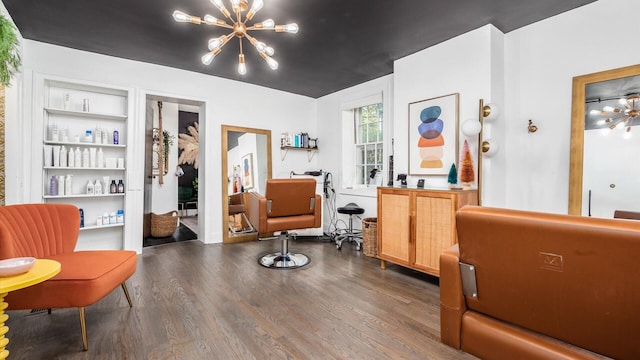 sitting room with dark hardwood / wood-style flooring, built in features, and an inviting chandelier