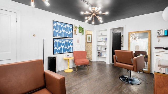 sitting room featuring a chandelier, built in shelves, and dark wood-type flooring