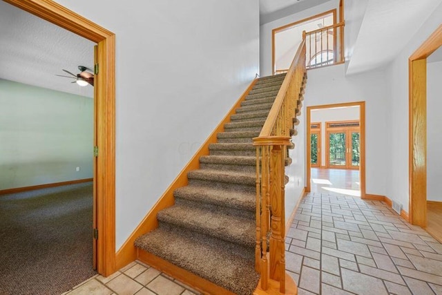 stairway featuring carpet and ceiling fan