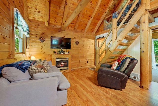 living room with a glass covered fireplace, wooden ceiling, wood walls, and lofted ceiling with beams