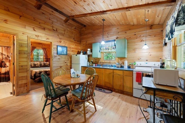 dining room with light wood-type flooring, wooden ceiling, wood walls, and lofted ceiling