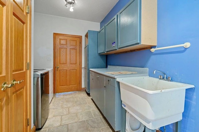 laundry area featuring washer and clothes dryer, cabinets, and sink