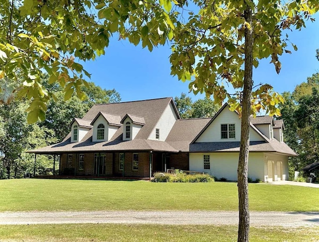 view of front facade with a garage, a front lawn, and brick siding