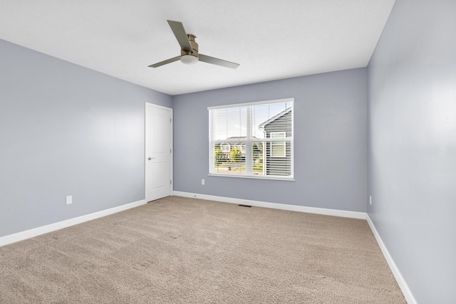 spare room with ceiling fan and carpet