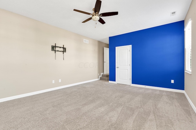 empty room featuring ceiling fan and carpet floors