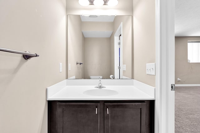 bathroom with vanity, toilet, and a textured ceiling