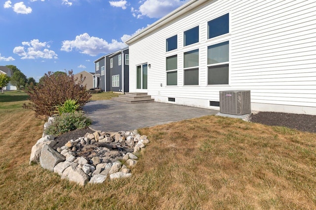 view of property exterior featuring a lawn, central air condition unit, and a patio