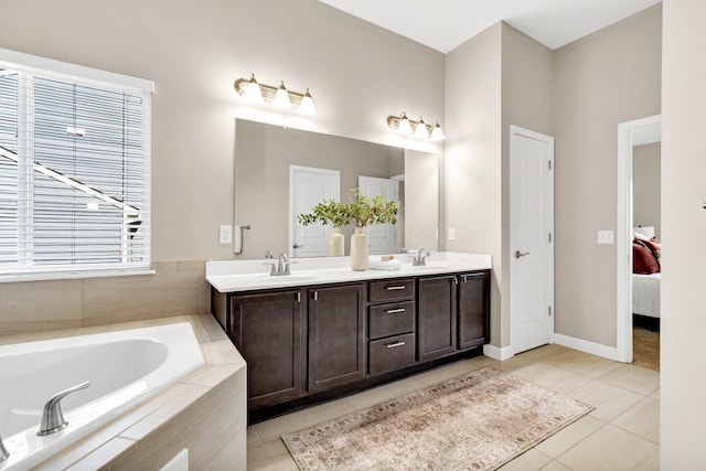 bathroom featuring tile patterned floors, vanity, and tiled tub