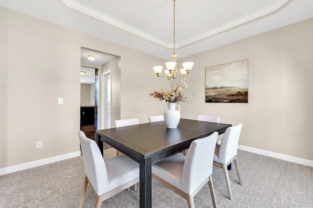 dining area with a chandelier, carpet, a tray ceiling, and crown molding