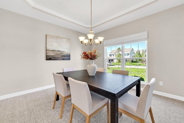 dining space with a tray ceiling, carpet floors, a chandelier, and ornamental molding