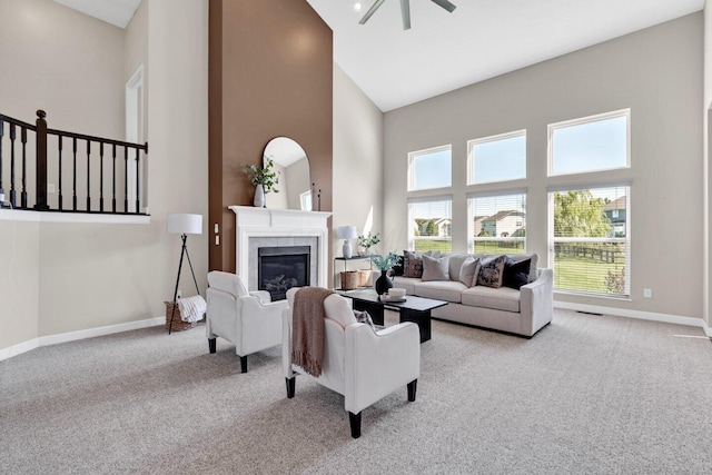 living room with a fireplace, ceiling fan, light carpet, and high vaulted ceiling