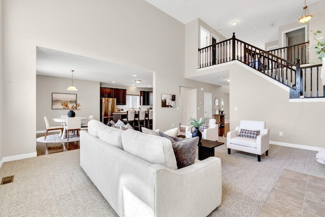 carpeted living room with a towering ceiling