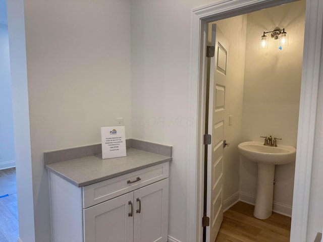 bathroom featuring a sink, baseboards, and wood finished floors