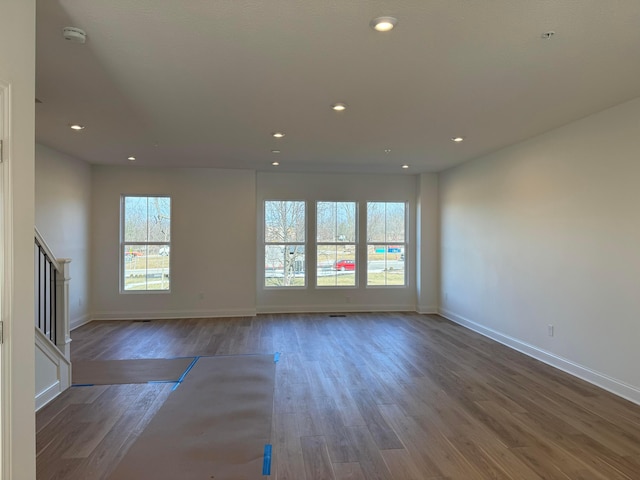 unfurnished living room featuring recessed lighting, stairway, baseboards, and wood finished floors