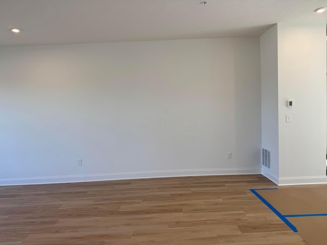 unfurnished room featuring recessed lighting, light wood-type flooring, visible vents, and baseboards