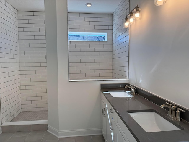 full bath with tile patterned flooring, a sink, a tile shower, and double vanity