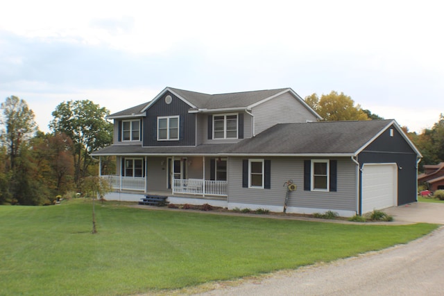 view of front of property featuring covered porch, a garage, and a front yard