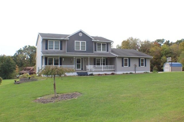 view of front of property featuring a front lawn, covered porch, and a storage shed