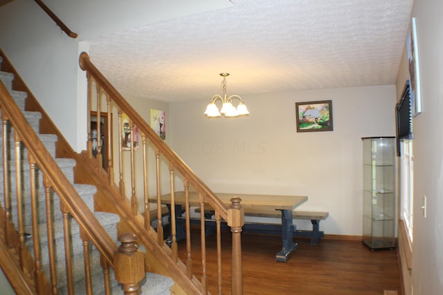 interior space featuring wood-type flooring, a textured ceiling, and a chandelier