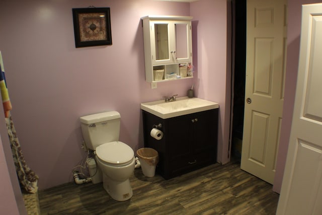 bathroom featuring vanity, wood-type flooring, and toilet