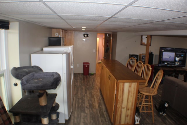 bar with washer / dryer, dark hardwood / wood-style flooring, and a drop ceiling