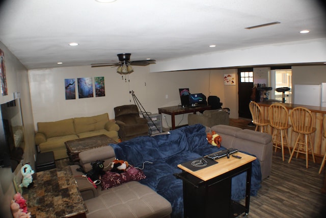 living room featuring ceiling fan and dark wood-type flooring