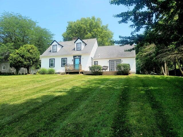 back of house featuring a lawn and a deck