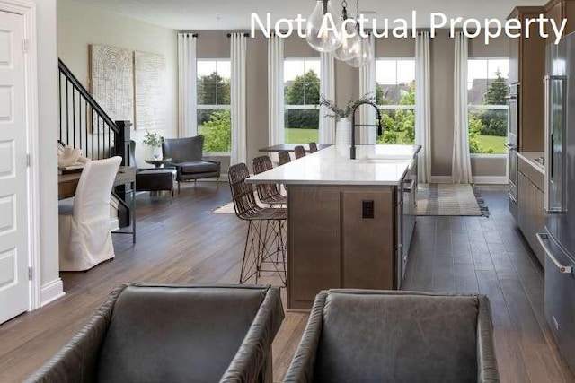 kitchen featuring decorative light fixtures, plenty of natural light, dark wood-type flooring, and sink