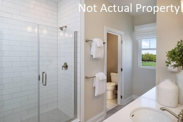 bathroom featuring vanity, toilet, and a shower with door